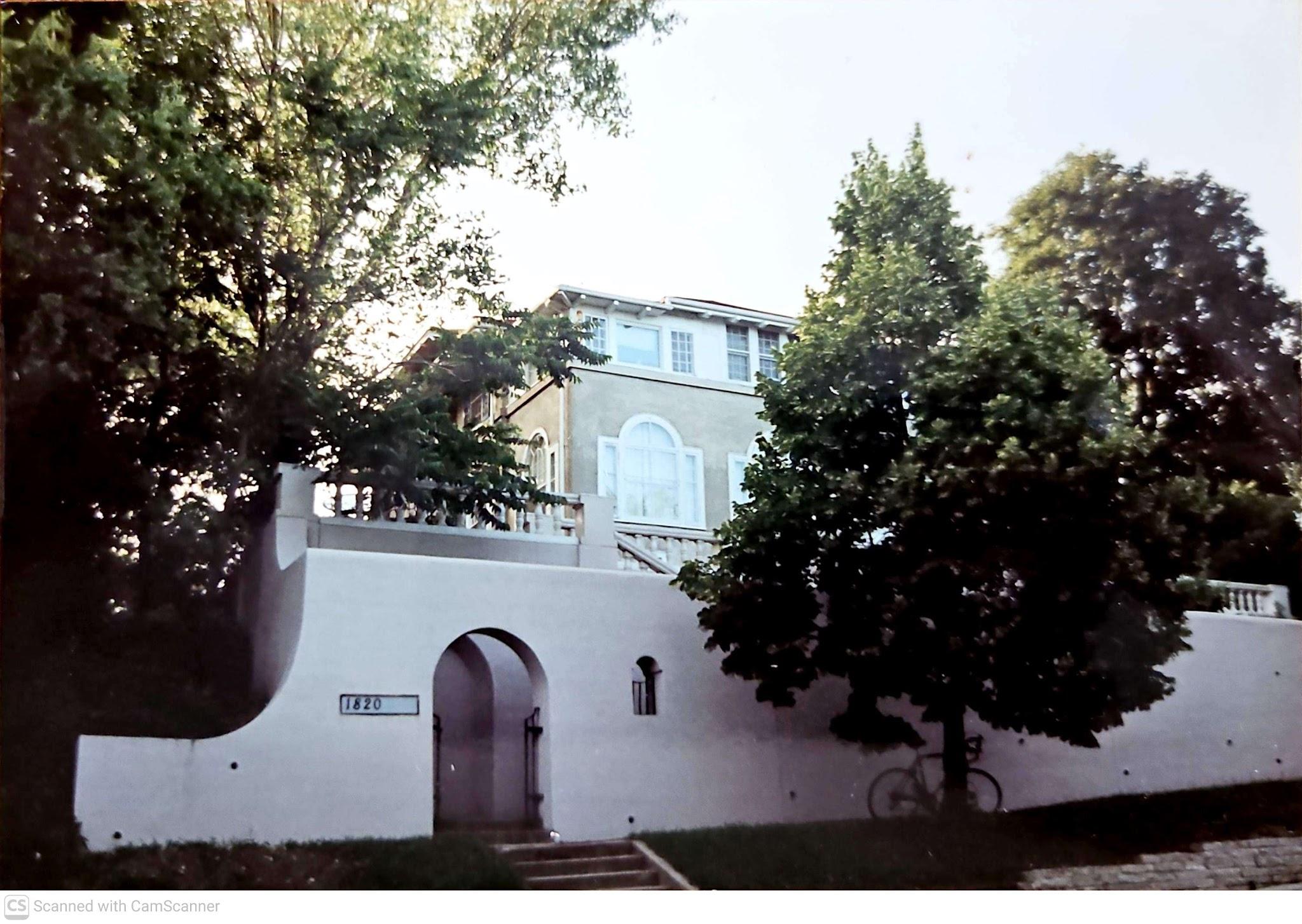 Street view of arched entry set in large retaining wall, 1994