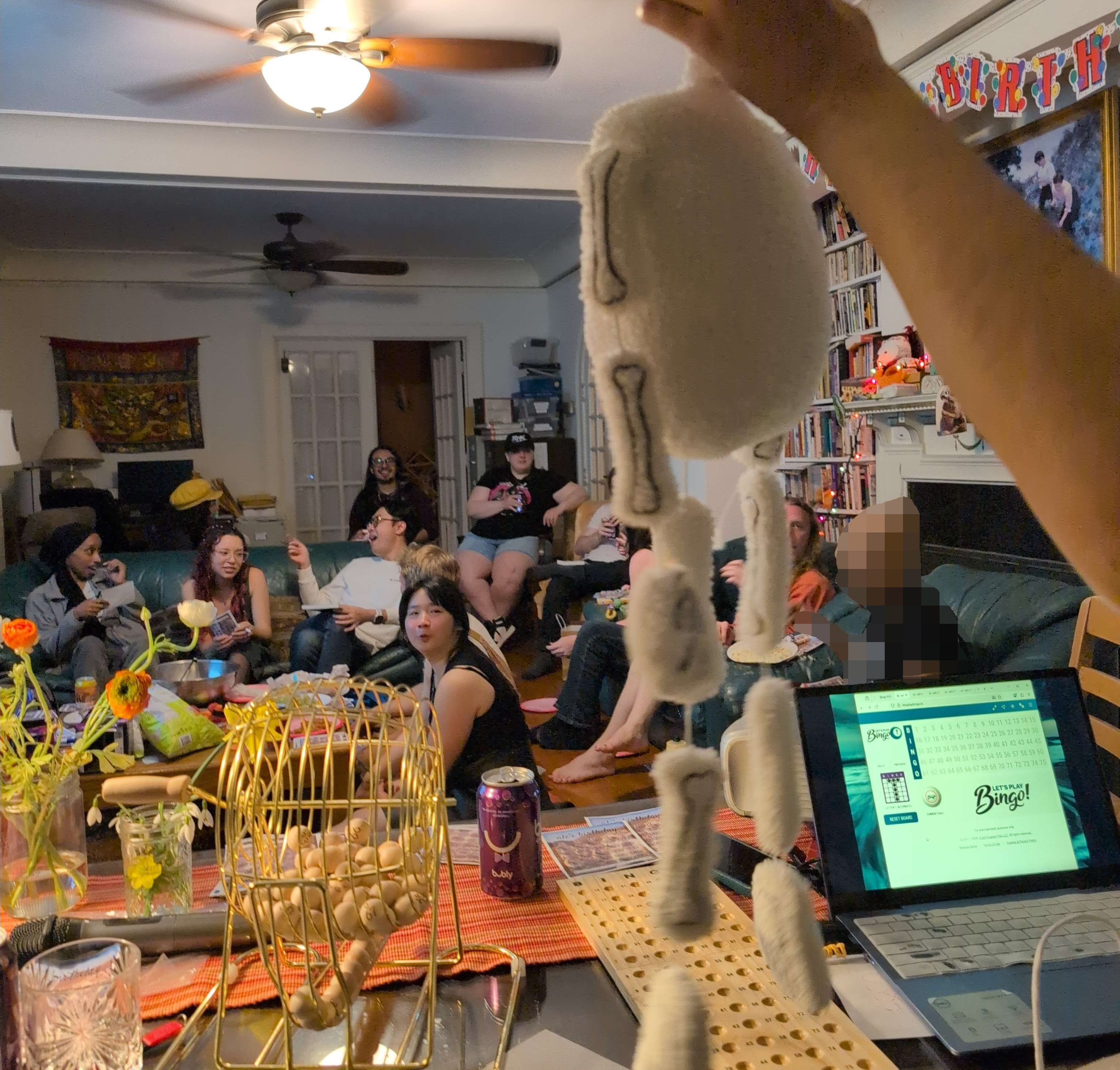 Skeleton plushie held in front of the the camera with Summiteers and friends in the background