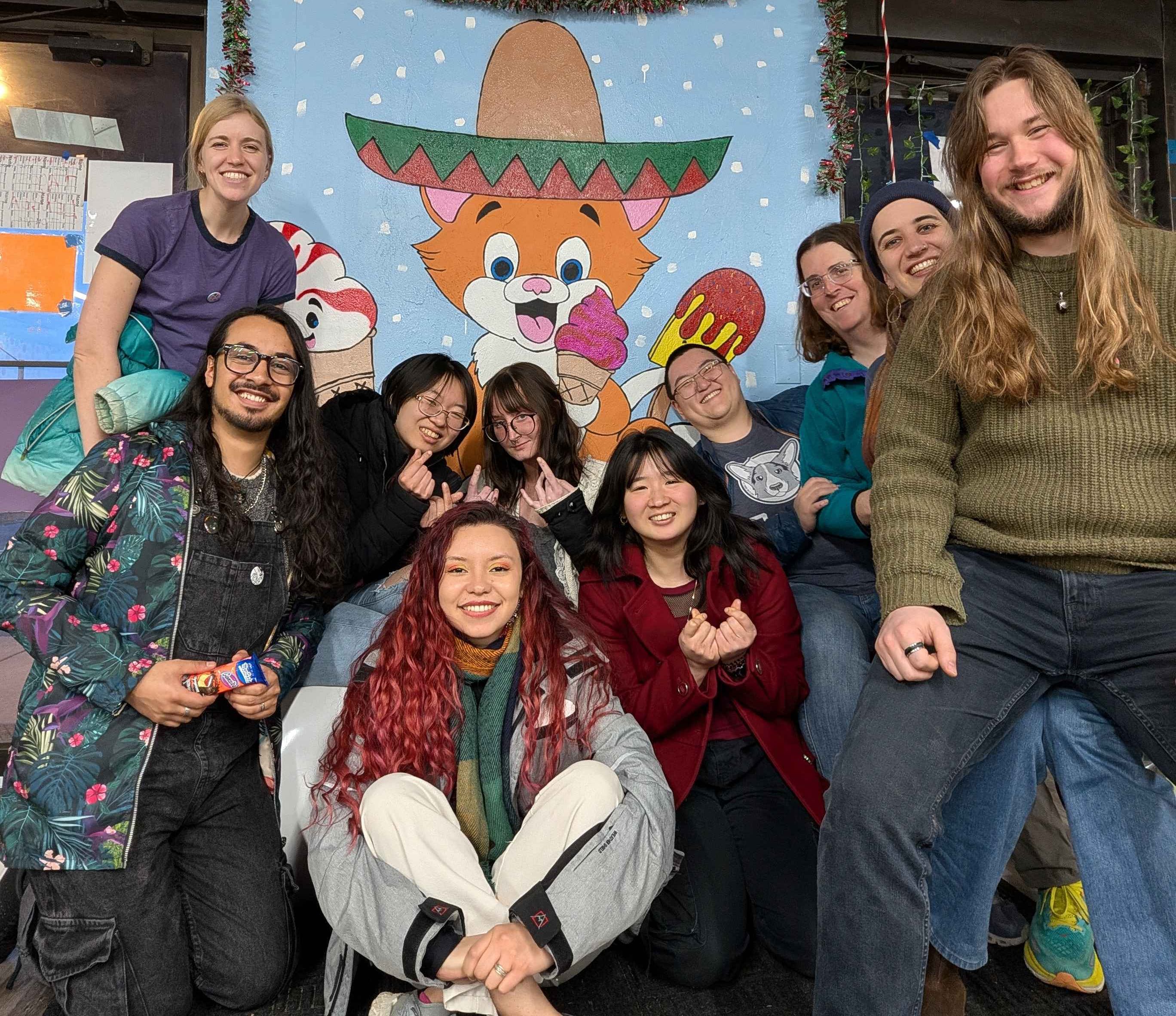 Ten Summiteers pose in front of a cat wearing a sombrero at the Taco Gato (March 2026)